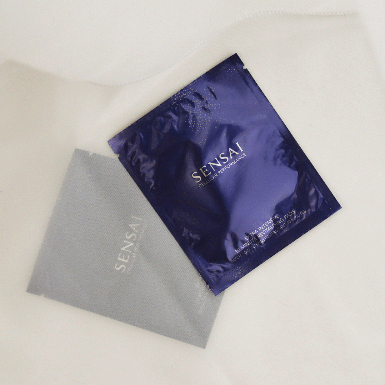 Cellular Performance Extra Intensive 10-minütige revitalisierende Pads, Verpackung auf neutralem Hintergrund und Pads auf Augen- und Mundpartie des Models